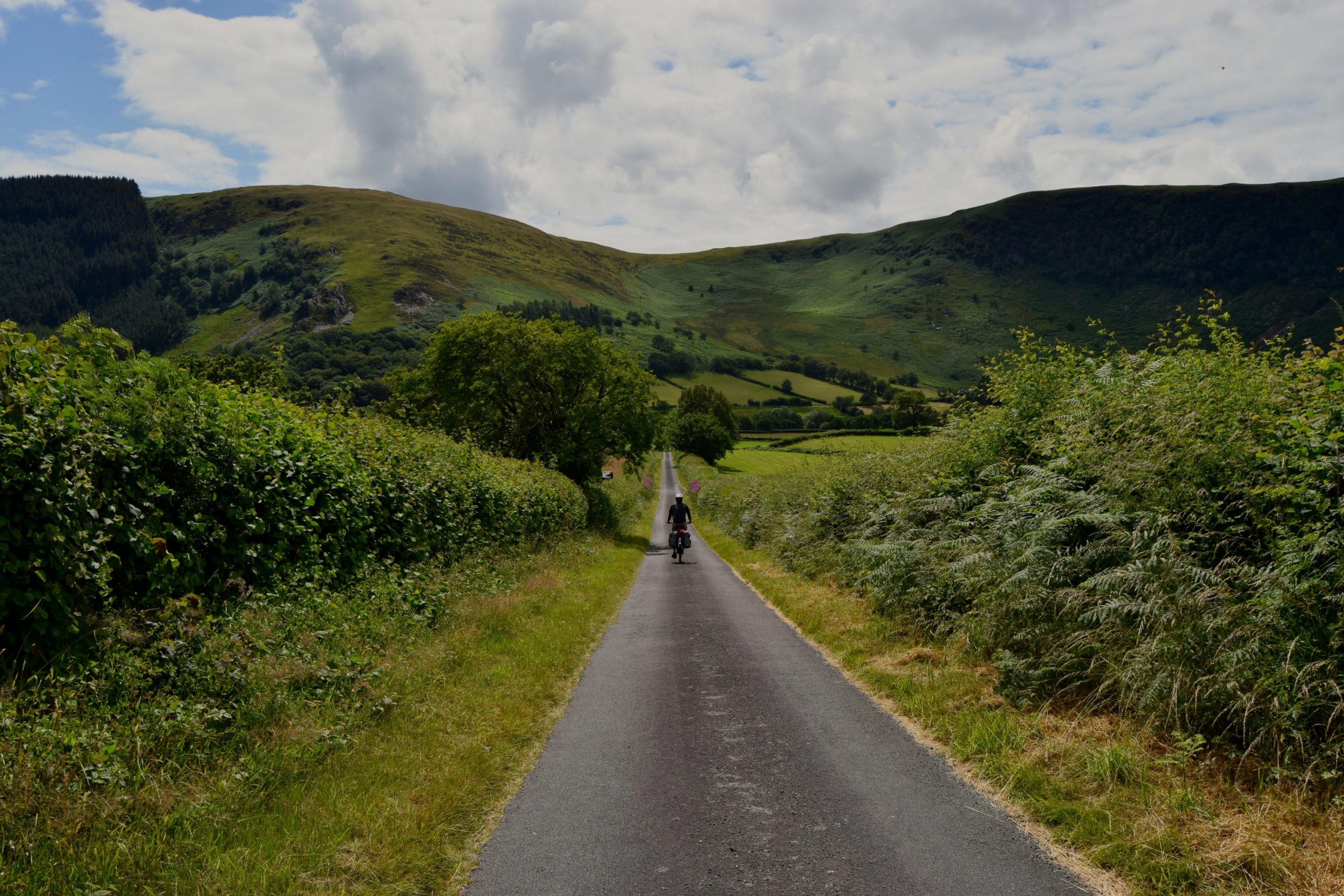 Lone cyclist on a straight country lane